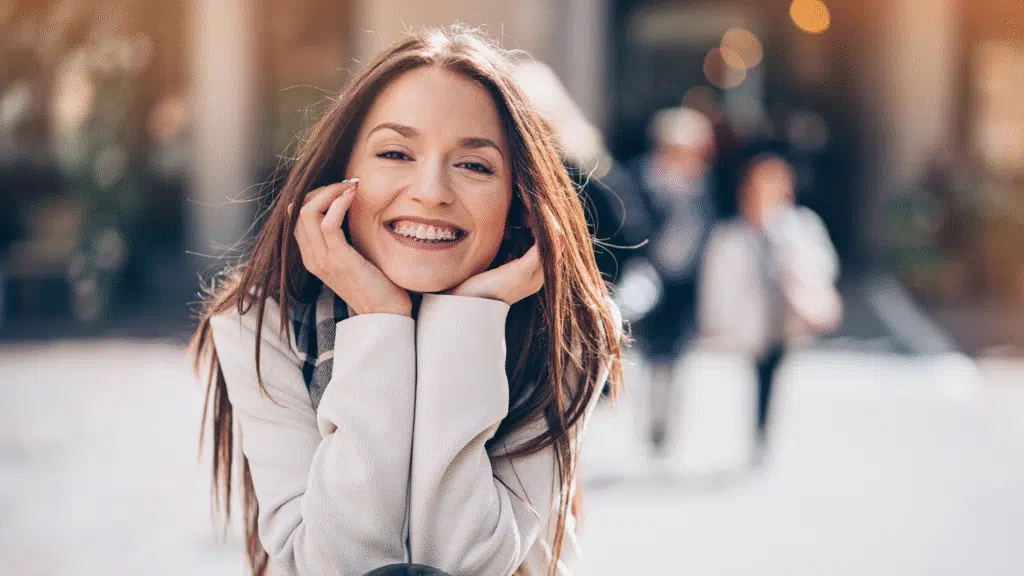 Image of a patient smiling with ceramic braces: