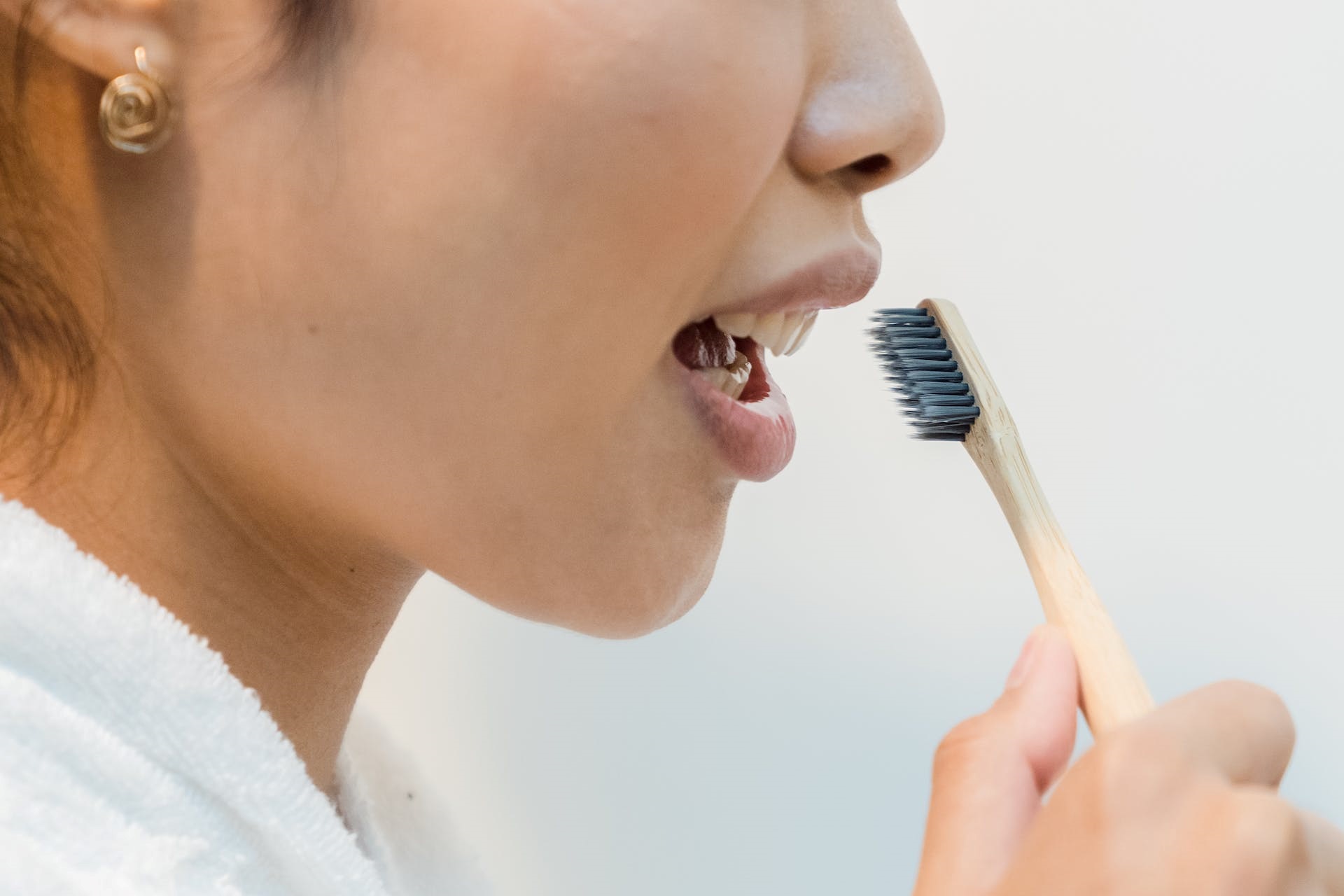 a woman holding a toothbrush in front of her mouth