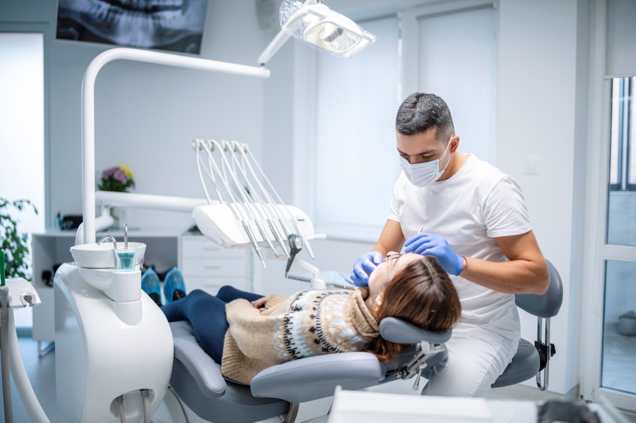 Dentist examining a female patient at a dental clinic.