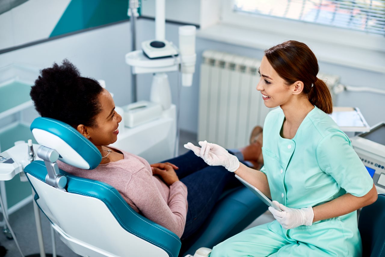 woman communicating with her dentist during dental procedure at dentist's office.