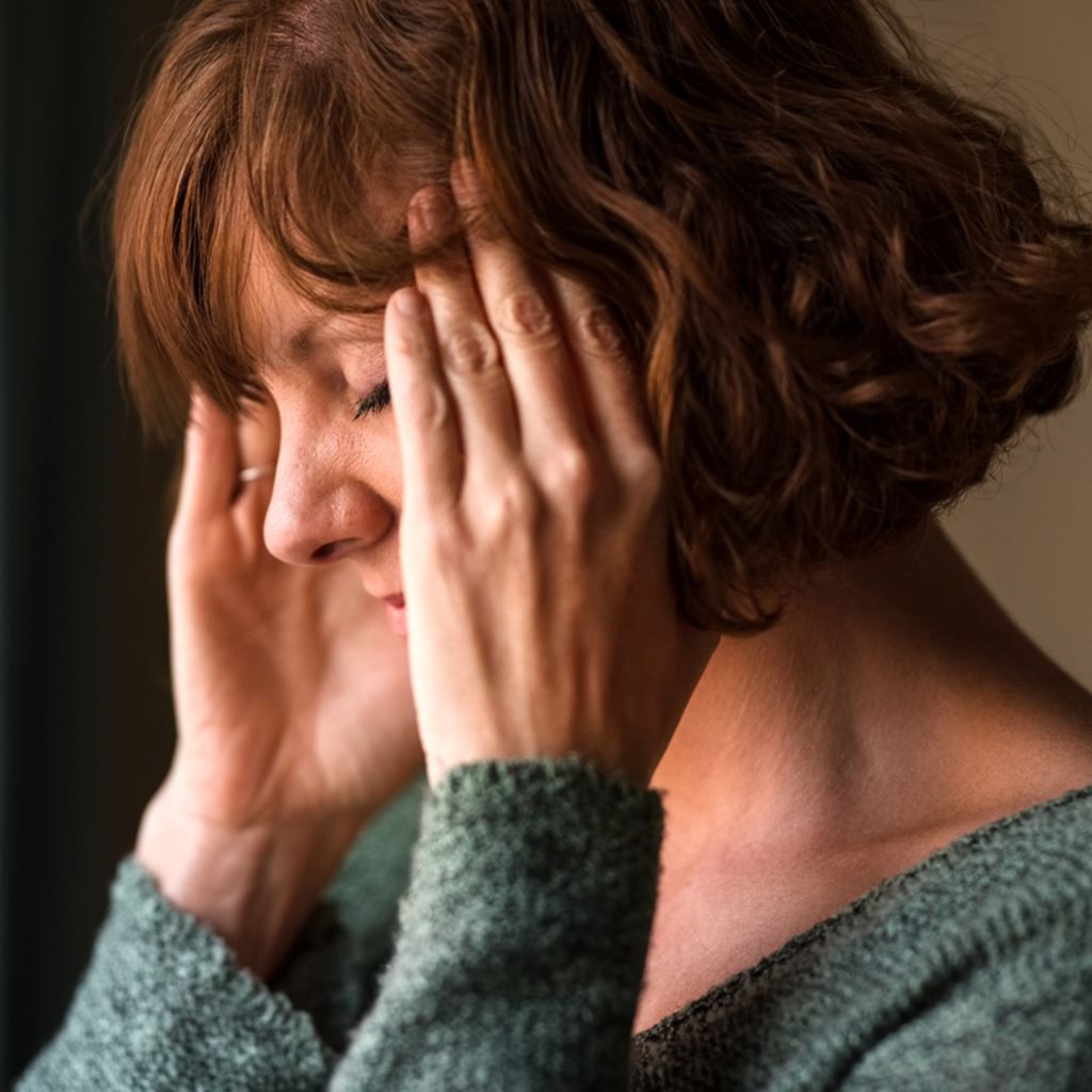 woman suffering from a headache and rubbing her temples